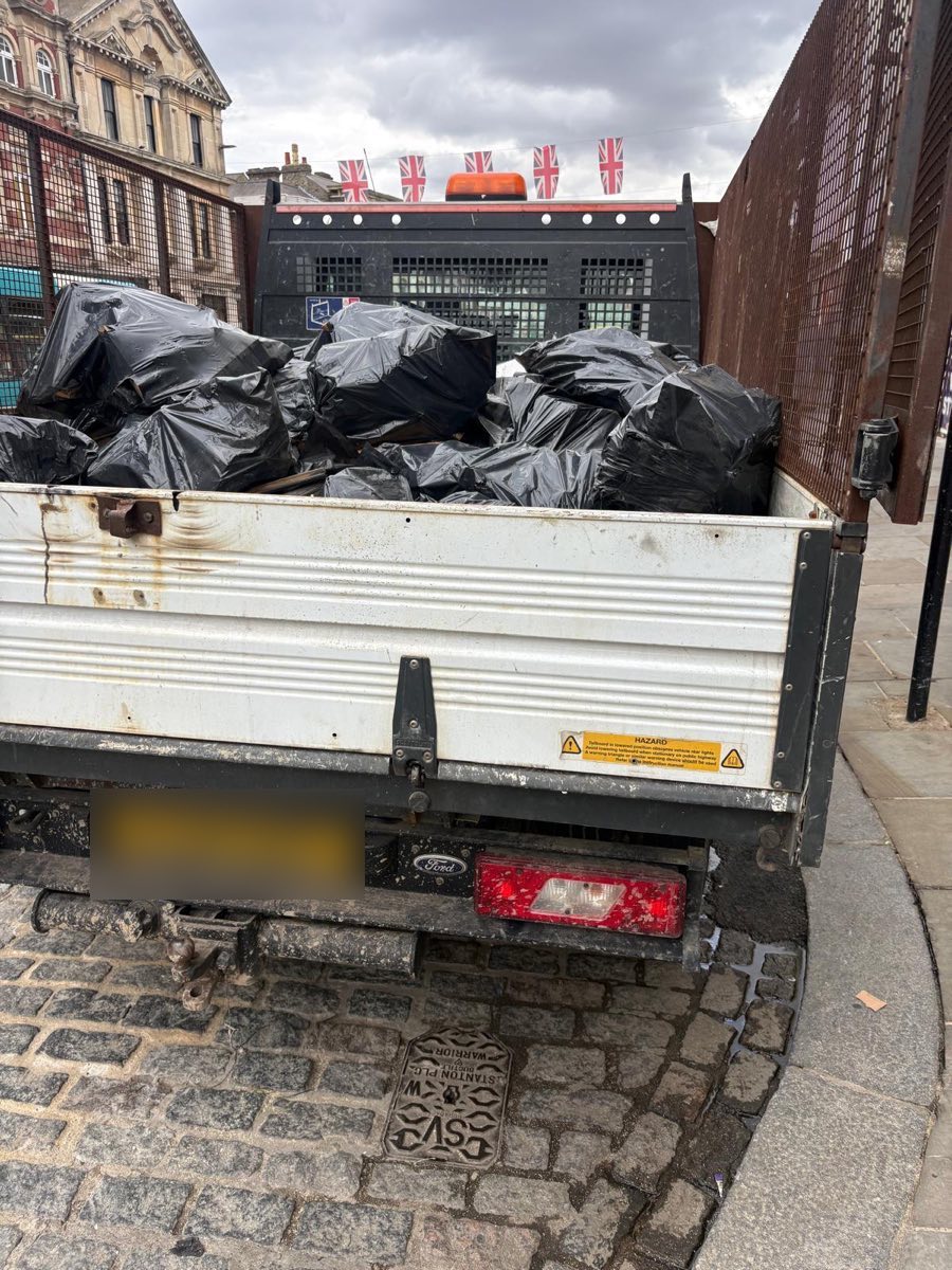 JWL flatbed loaded with commercial waste bags on a London street